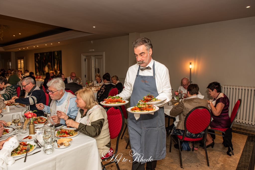 Een ober serveert het kreeftengerecht
