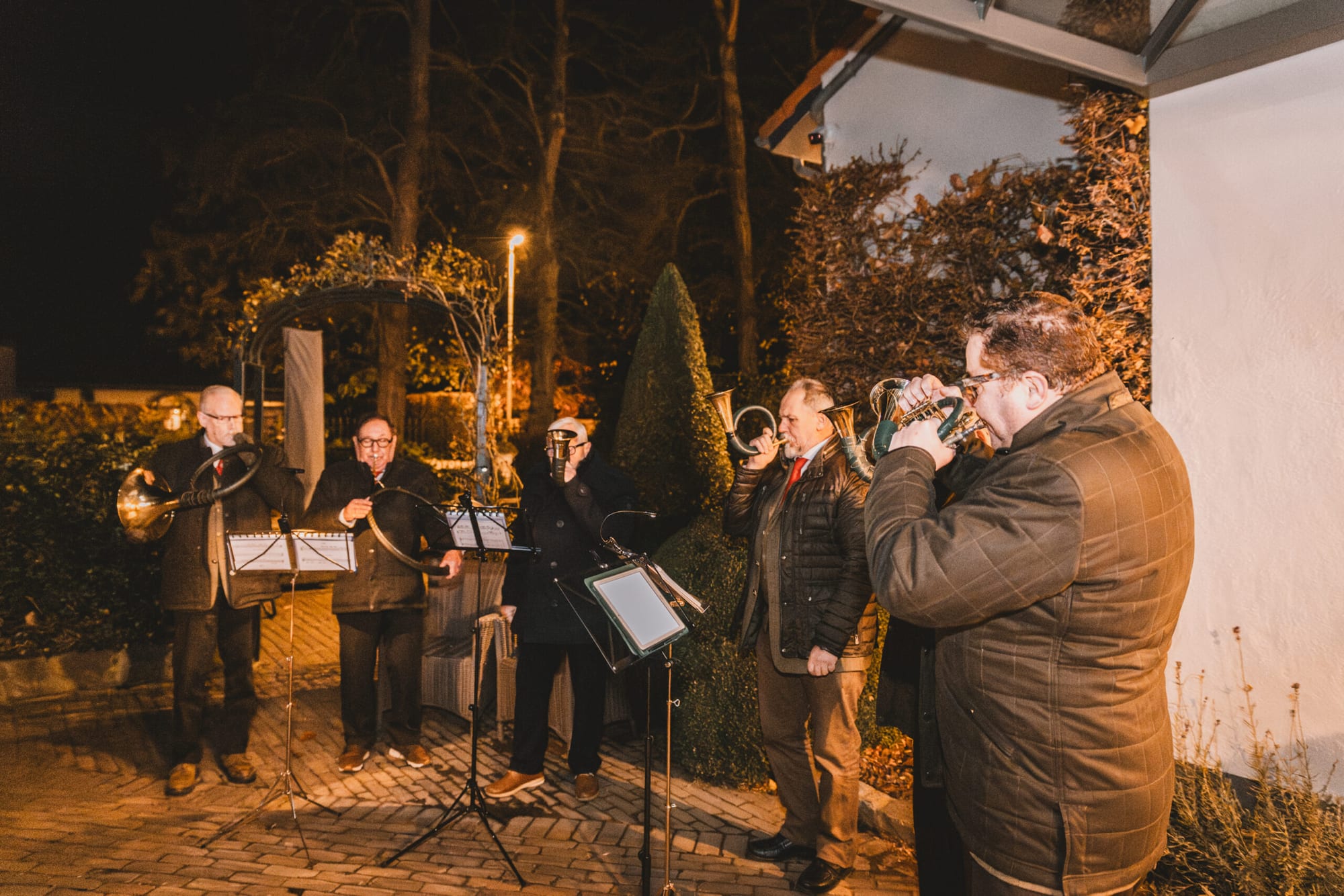 De jachthoorngroep speelt buiten bij avondlicht