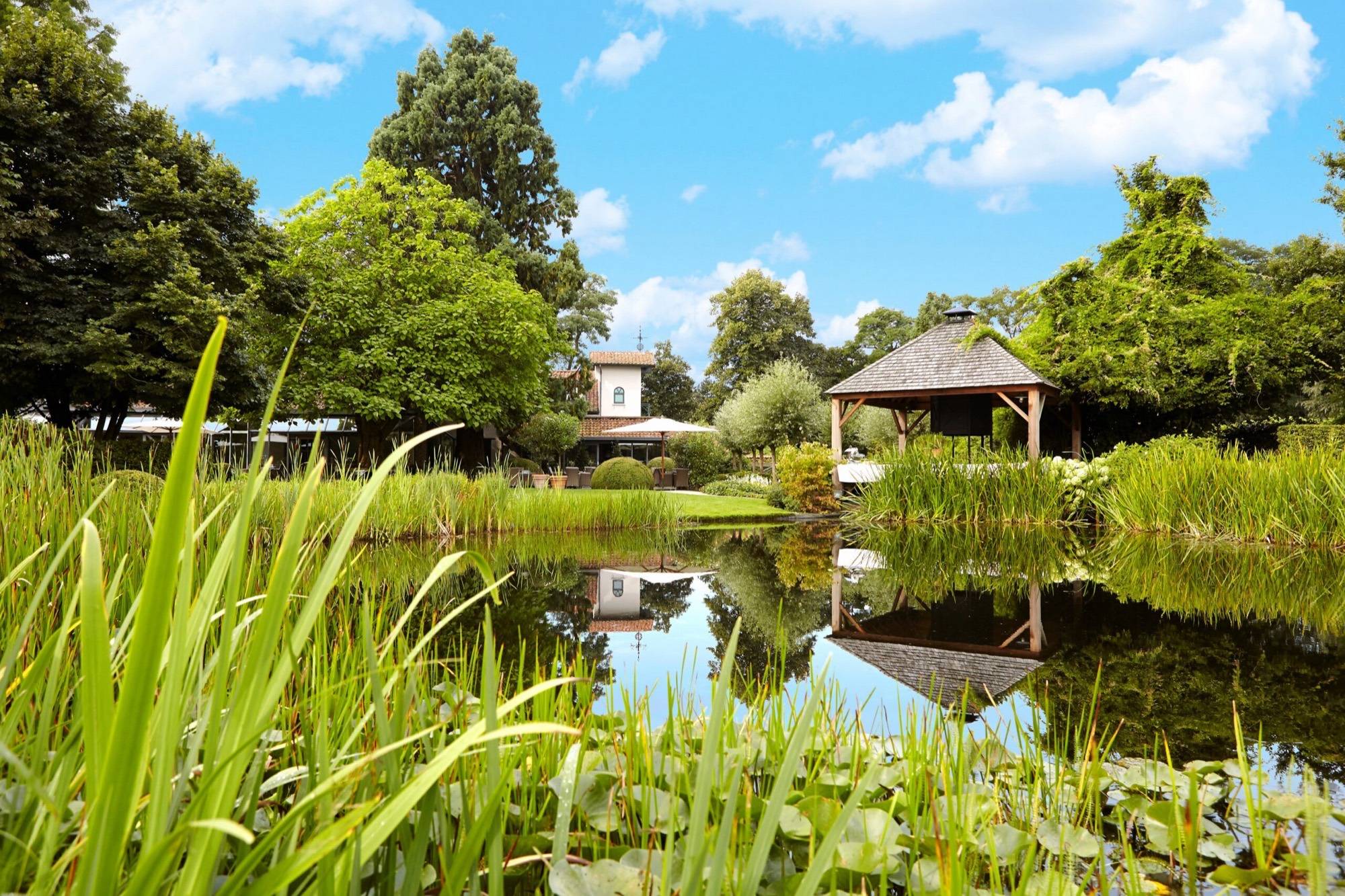 De vijver en het prieel in de tuin van Hof te Rhode